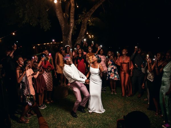 A vibrant wedding party celebrating under lights in Nigeria.