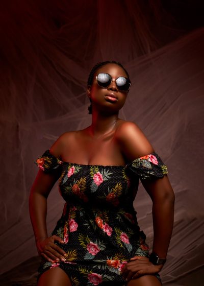 Elegant portrait of a model in Lagos, showcasing floral fashion and sunglasses.